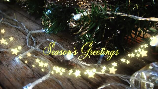Animation of text, season's greetings, in yellow, over string lights and christmas decorations