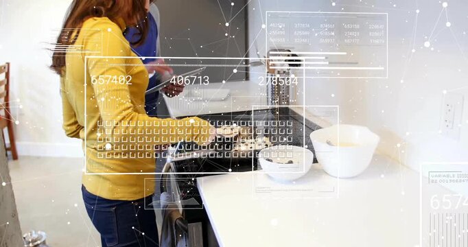 Woman flipping with spatula on stove with partner using tablet, showing food tech data overlay