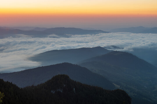 Panoramic sunrise view over Ceahlau Mountains near Cabana Dochia, Romania, with sea of clouds and layered ridgelines