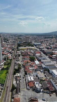 Vista a&eacute;rea da cidade de Mogi das Cruzes no Alto Tiet&ecirc; paulista destaca urbaniza&ccedil;&atilde;o, linha f&eacute;rrea e crescimento urbano da regi&atilde;o.