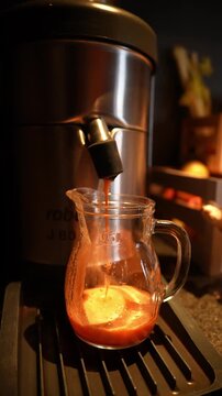 Vertical shot shows espresso pouring into a clear 0.5L jug, crema swirling. Partial branding reads rob and J80. Warm amber light, shallow depth of field.
