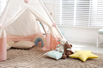Toy wigwam with pillows in room, closeup. Space for text © New Africa