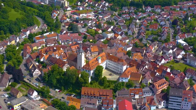An panoramic aerial view around the old town in the city Waldenbuch on a sunny summer noon in Germany .