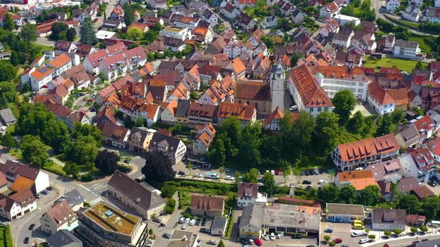 An panoramic aerial view around the old town in the city Waldenbuch on a sunny summer noon in Germany .