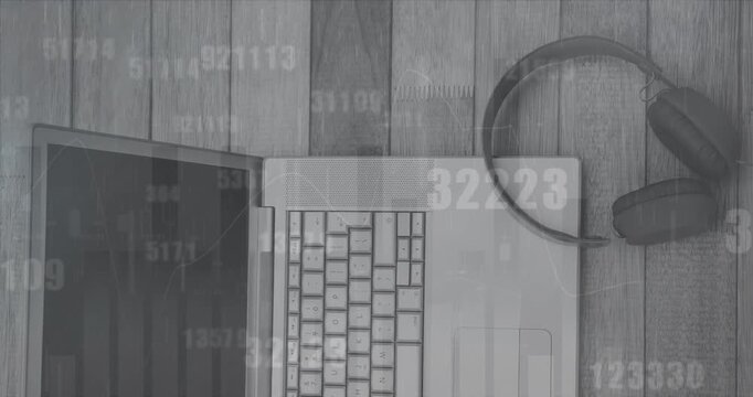 Animation of data processing and changing numbers over laptop and headphones on wooden surface