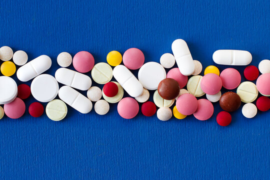 Pills and capsules lined up in the center of the background. Close-up. Photo with space for text