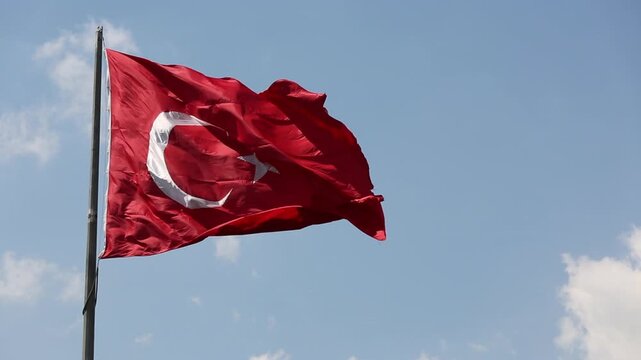 Turkish Flag Waving Against Blue Sky With Crescent Моон and Star Symbol Overhead