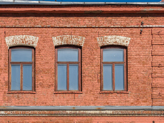 Fototapeta premium Three windows of the old mansion 19 century with brown bricks wall