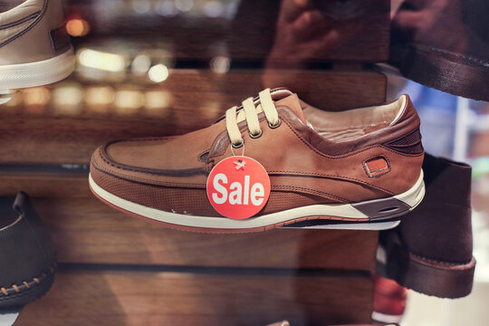 Brown Leather Casual Shoe With Red Sale Tag Displayed in Shoe Store Window