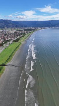 Vista a&eacute;rea da praia do Porto Novo evidenciando mar, areia e vegeta&ccedil;&atilde;o destacando o litoral paulista como destino tur&iacute;stico e natural