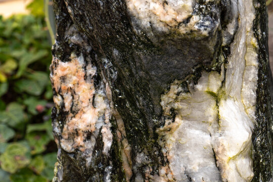 Feinstrukturierter Naturstein in Wei&szlig;-, Rosa- und Graut&ouml;nen mit sanft herablaufendem Wasser als nat&uuml;rliche Textur