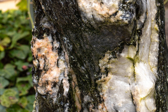 Natursteintextur in Wei&szlig;-, Rosa- und Graut&ouml;nen mit herablaufendem Wasser auf der Oberfl&auml;che