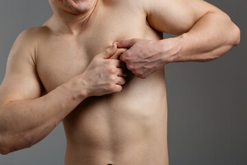 Obraz premium A young guy with an athletic build is experiencing painful sensations in the heart area. The concept of: heart disease, first aid, men's health