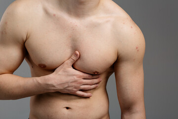 Obraz premium A young guy with an athletic build is experiencing painful sensations in the heart area. The concept of: heart disease, first aid, men's health