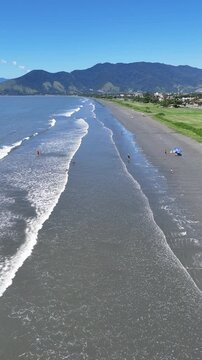 Vista panor&acirc;mica a&eacute;rea da Praia do Porto Novo com mar e vegeta&ccedil;&atilde;o ao longo da costa, representando cen&aacute;rio natural e destino tur&iacute;stico no litoral norte paulista
