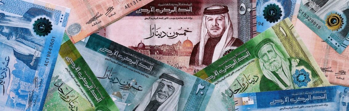 Jordanian dinar money bills pile on table. Jordan banknotes of JOD currency close up.