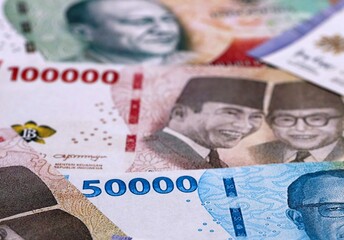 Indonesian rupiah money bills pile on table. Indonesia banknotes of IDR currency close up. © Larysa