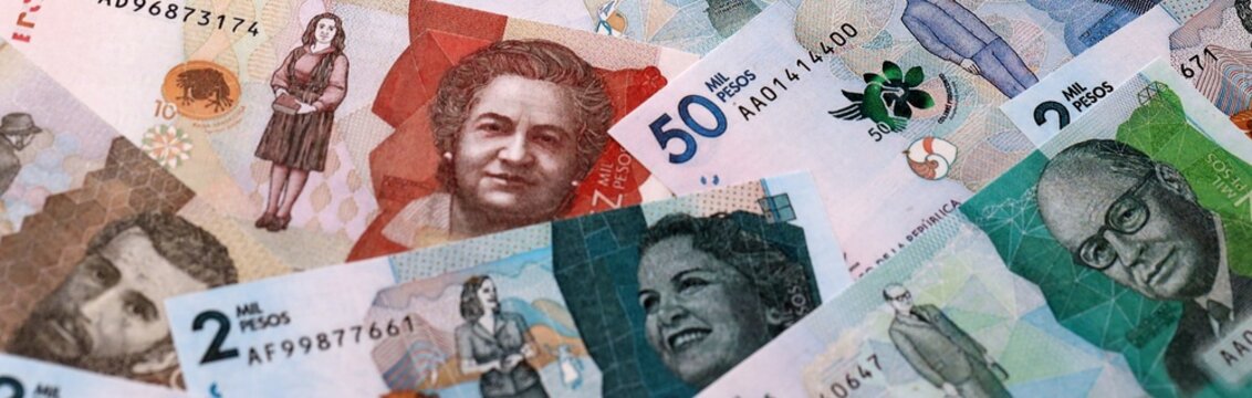 Colombian peso money bills pile on table. Colombia banknotes of COP currency close up.