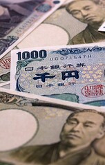 Japanese yen money bills pile on table. Japan banknotes of JPY currency close up. © Larysa