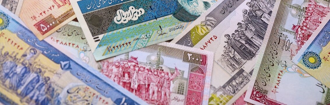 Iranian rial money bills pile on table. Iran banknotes of IRR currency close up.