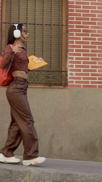 Happy young student dancing in the street