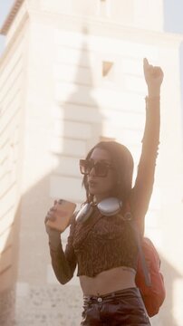 Happy young woman dancing in the city street
