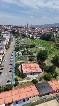 Vista a&eacute;rea do Parque da Cidade em Mogi das Cruzes destaca &aacute;reas verdes, lago ornamental, espa&ccedil;os de lazer e a integra&ccedil;&atilde;o do parque com o cen&aacute;rio urbano.