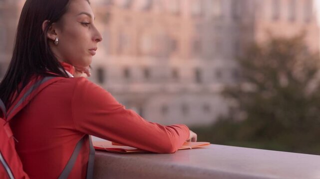 Young female student contemplating the future at sunset