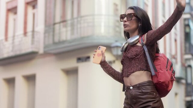 Happy energetic young woman dancing in Madrid street