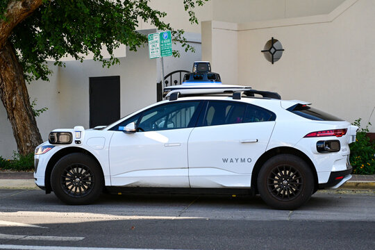 Waymo autonomous vehicle equipped with sensors and cameras parked on a street, representing self driving technology, mobility innovation, and urban transportation development