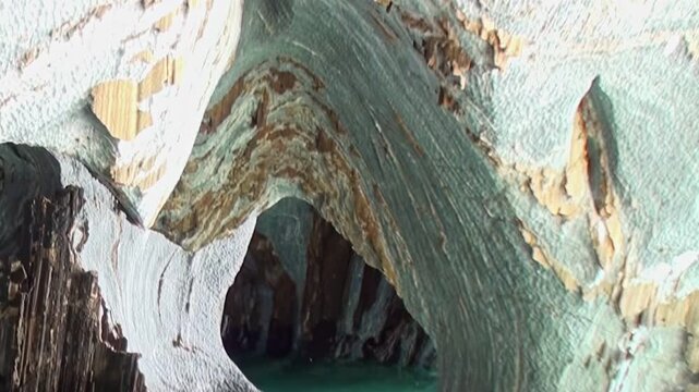 Drifting through wondrous Marble Caves of Patagonia, intricate marble walls with swirling patterns reveal nature's grand design. Turquoise waters gently mirror ancient stone, mystical atmosphere.