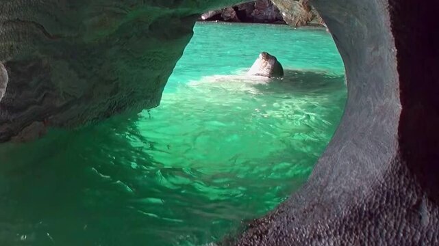 Glimpse the dazzling turquoise and emerald waters inside the Marble Caves of Patagonia. Unique rock formations sculpted by nature shimmer on a bright day.