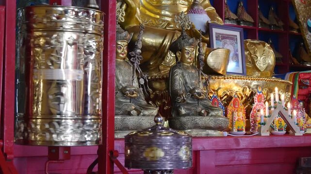  The interior of a Buddhist temple in Mongolia. Bronze figures of deities and a spinning prayer wheel.