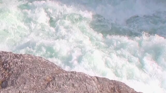 Turbulent, emerald waters pummel jagged rocks. This powerful cascade roars through Los Alerces National Park in the captivating landscapes of northern Patagonia, Argentina.