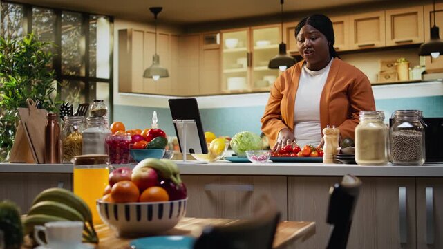 African american influencer answering questions in the comments, engaging with the audience online after livestream. Woman content creator filming homemade food vlog, making a recipe.