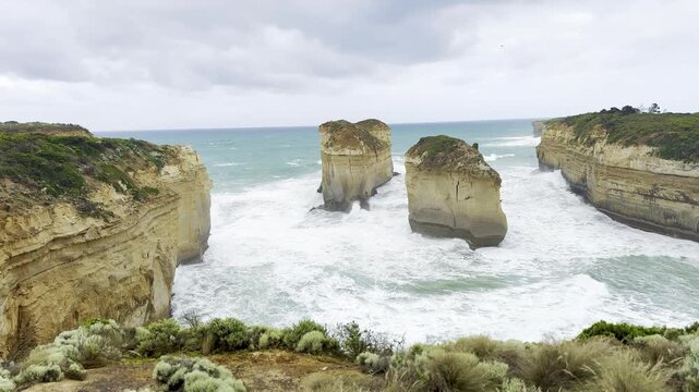 Powerful waves crashing against the limestone cliffs, stacks of the Twelve Apostles in Port Campbell National Park on the Great Ocean Road, Victoria, Australia