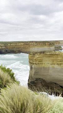 Powerful ocean waves crashing against the dramatic cliffs at the Loch Ard Gorge viewpoint near the Twelve Apostles on the Great Ocean Road, Victoria, Australia