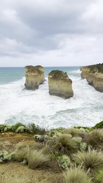 Powerful waves crashing against the limestone cliffs, stacks of the Twelve Apostles in Port Campbell National Park on the Great Ocean Road, Victoria, Australia