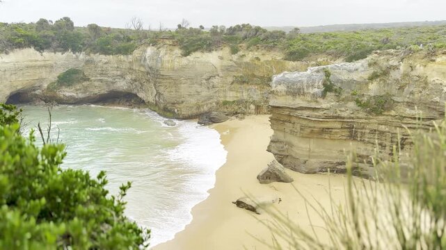 Powerful ocean waves crashing against the dramatic cliffs at the Loch Ard Gorge viewpoint near the Twelve Apostles on the Great Ocean Road, Victoria, Australia