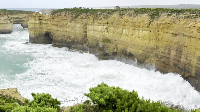 Powerful ocean waves crashing against the dramatic cliffs at the Loch Ard Gorge viewpoint near the Twelve Apostles on the Great Ocean Road, Victoria, Australia