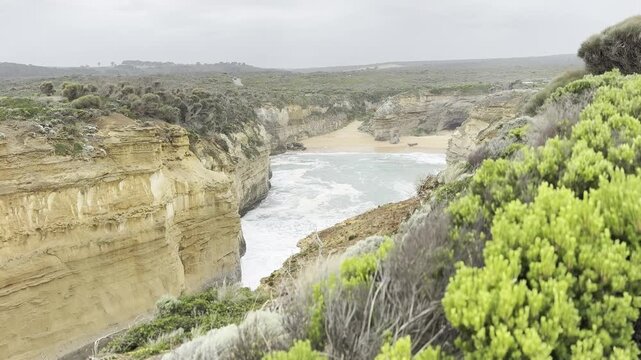Powerful ocean waves crashing against the dramatic cliffs at the Loch Ard Gorge viewpoint near the Twelve Apostles on the Great Ocean Road, Victoria, Australia