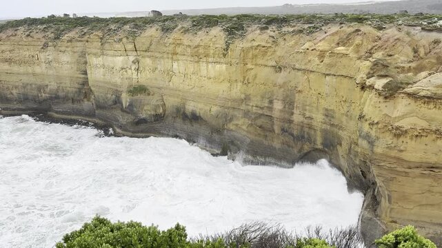 Powerful waves crashing against the limestone cliffs, stacks of the Twelve Apostles in Port Campbell National Park on the Great Ocean Road, Victoria, Australia