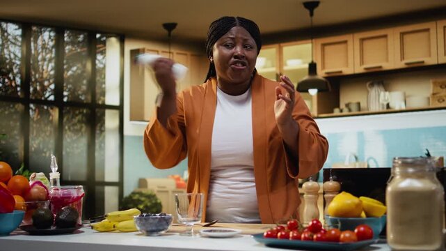 Female influencer pouring yogurt in a bowl for a nutritious breakfast idea, preparing a chia pudding for healthy meal choice. Woman content creator recording tutorial at home.