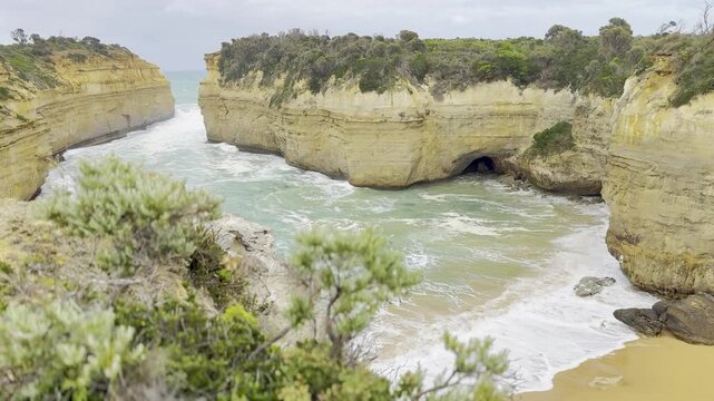 Powerful ocean waves crashing against the dramatic cliffs at the Loch Ard Gorge viewpoint near the Twelve Apostles on the Great Ocean Road, Victoria, Australia
