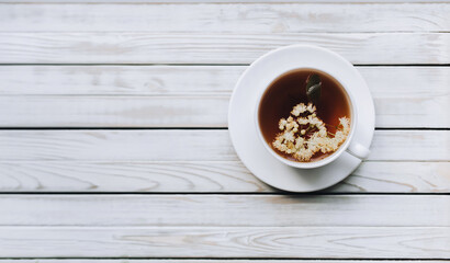 Tea in a cup of dried linden flowers on a wooden background, copy space. Morning breakfast. Subject photography.
