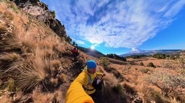 Hiker filming a selfie video hiking on a mountain trail