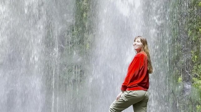 Girl adventurer stands on rock and admires the powerful Beauchamp Falls, surrounded by lush vegetation, located in Great Otway National Park, Victoria, Australia. Stunning waterfalls in the Otways reg