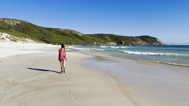 Happy girl walks along the stunning paradise Squeaky Beach with white sand and turquoise water in Wilsons Promontory National Park, Squeaky Beach Road, Yanakie, Victoria, Australia