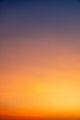 Fototapeta premium Sunset or sunrise sky with a vibrant gradient of orange, gold, and soft blue. Clear atmosphere with wispy clouds. Peaceful, natural light background. hope, freedom, new day and inspirational Concepts
