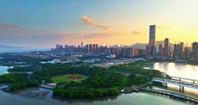 Aerial view of Shenzhen city skyline with modern skyscrapers and lush urban park at sunset, China. Financial district urban landscape.